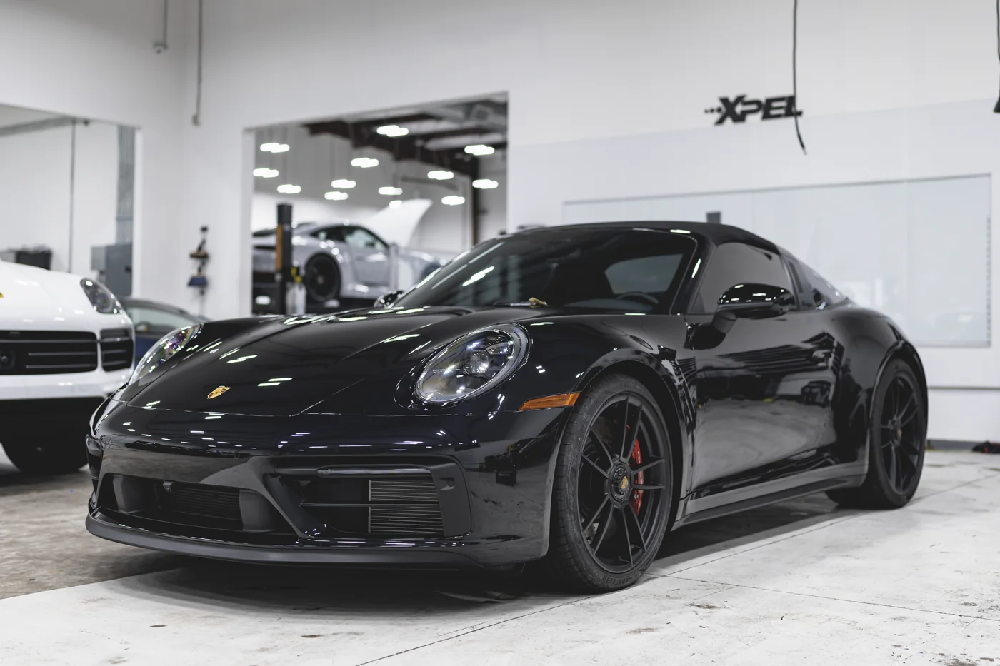A black Porsche 911 in an XPEL installation studio