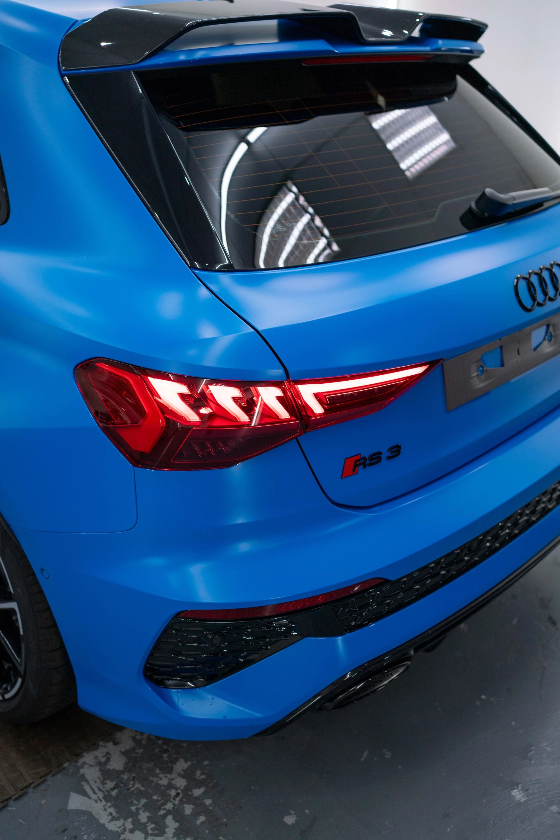 Rear three-quarter view of a blue Audi RS3 in a satin finish, representing the XPEL STEALTH PPF option