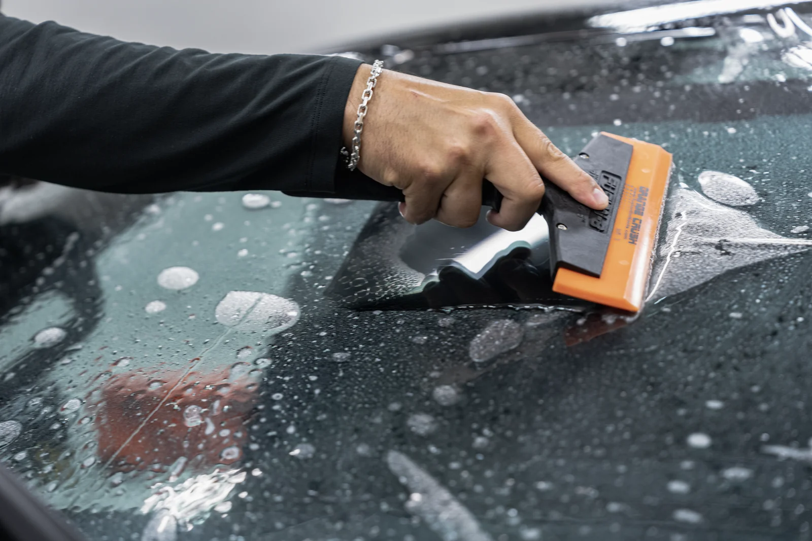 XPEL paint protection film being squeegeed onto a windscreen during installation