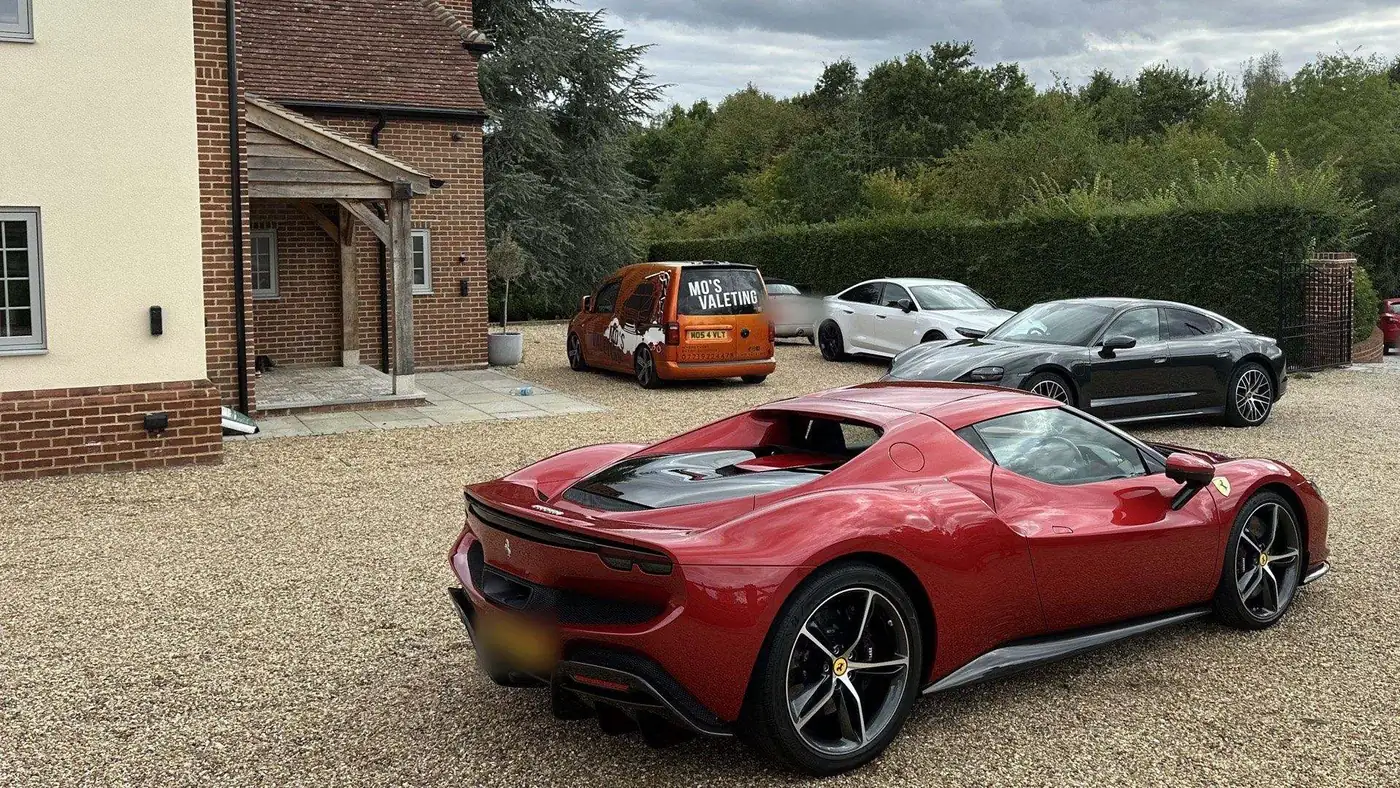 A red Ferrari 296 GTS on a gravel driveway with the Mo&rsquo;s Valeting van behind it