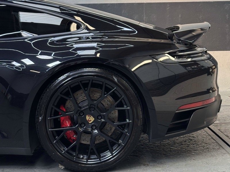 Porsche wheel and arch detail showing clean wheel spokes and red brake caliper